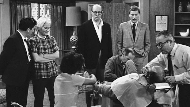 In this April 11, 1963, file photo, standing from left, Morey Amsterdam, Rose Marie, and Richard Deacon, and Dick Van Dyke, right, gather around Carl Reiner, in barber chair during a rehearsal of an episode for the "The Dick Van Dyke Show." 