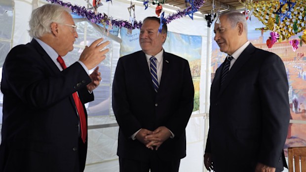 U.S. Secretary of State Mike Pompeo, center, Israeli Prime Minister Benjamin Netanyahu, right, and U.S. Ambassador to Israel David Friedman speak at a sukkah, a traditional shack built for the weeklong Jewish holiday of Sukkot