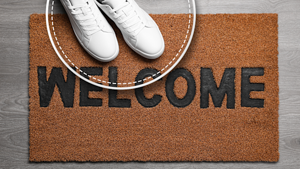 Shoes next to a welcome mat