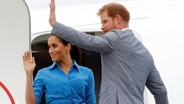 Meghan Markle and Prince Harry wave as they board plane during Australia and Pacific Islands Royal Tour in November 2018