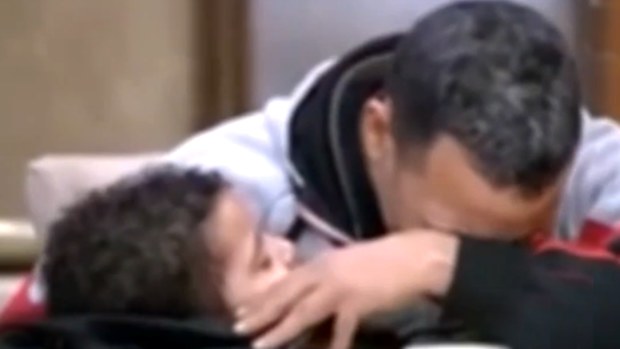 Ahmed Mansour Qurani Ali is held by his weeping father.