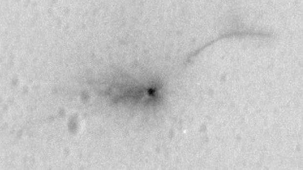 The crash site of the Mars probe. The line in the ground at the top right side of the photo is baffling scientists. (NASA)