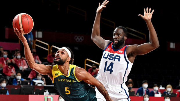 Patty Mills of Australia is fouled by Draymond Green of the USA during the Basketball semi final match between Australia and the USA on day thirteen of the Tokyo 2020 Olympic Games at Saitama Super Arena on August 05, 2021 in Saitama, Japan. (Photo by Bradley Kanaris/Getty Images)