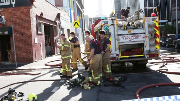 Firefighters attending the warehouse fire after a squatter was doused in petrol and set alight. 