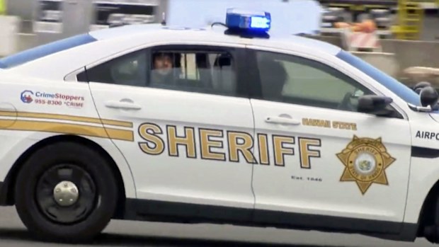 File image made from video provided by Hawaii News Now, Anil Uskanli is driven away from the airport in the back of a sheriff's car in Honolulu after being detained on an American Airlines flight from Los Angeles to Hawaii. (AP)