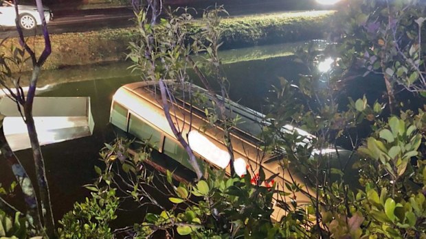 The partially submerged tourist bus in Smiths Creek, Cairns. Photo: Queensland Police. 