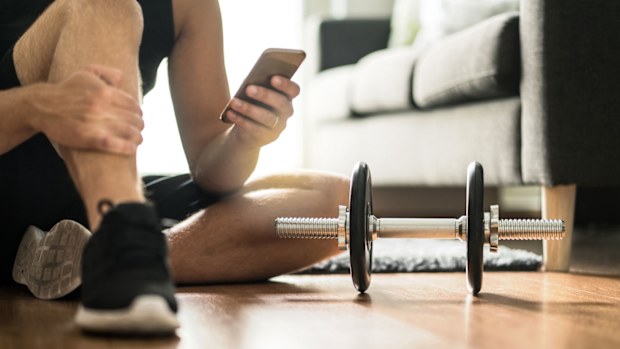 Man on phone workout at home weights