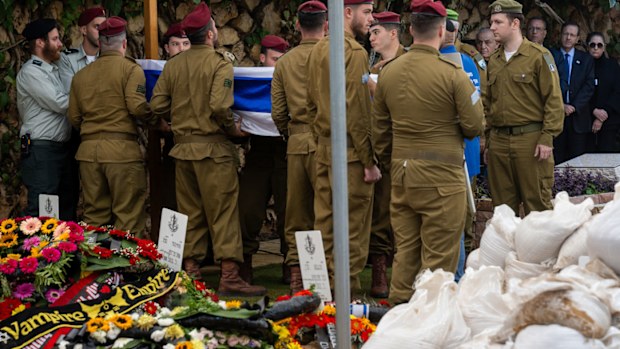 President of Israel Isaac "Bougie" Herzog (R) watches as the casket for 20-year-old Staff Sergeant Dvir Barzani is carried into the funeral led by IDF Chief Cantor Lt. Col. Shai Abramson at Har Herzel on November 21, 2023 in Jerusalem.