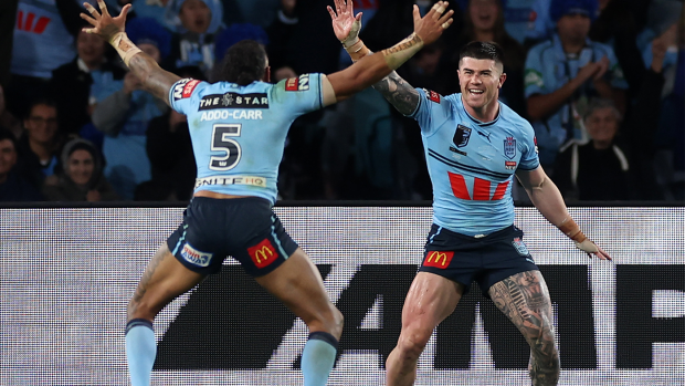 Bradman Best of the Blues celebrates with teammates after scoring a try during game three of the State of Origin series.