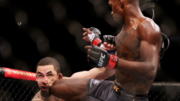 Israel Adesanya of Nigeria kicks Robert Whittaker of Australia in their middleweight championship fight during UFC 271