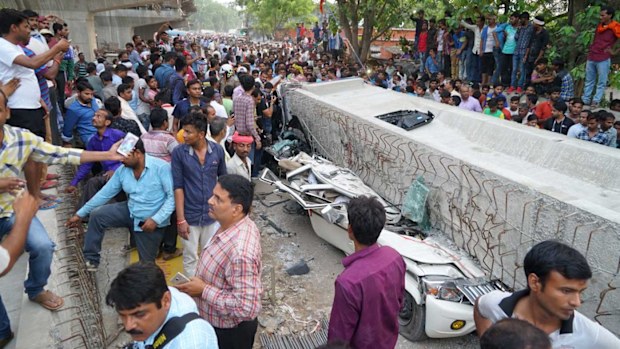 People crowd around the site of an accident where a section of an under construction overpass collapsed in Varanasi, India. (AAP)
