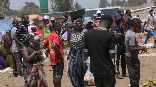 People are seen at a busy market in a poor township on the outskirts of the capital Harare in Zimbabwe.