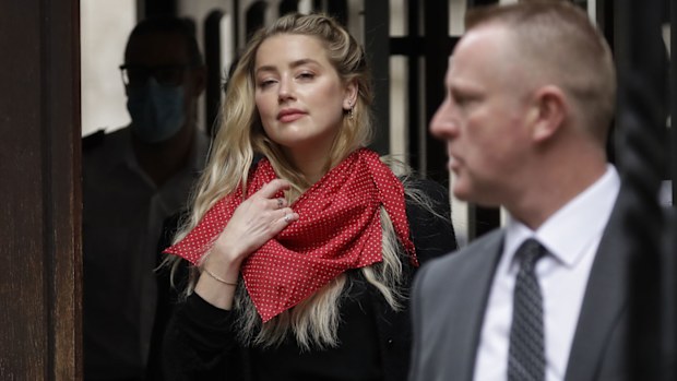 American actress Amber Heard waves at the media as she arrives at the High Court in London, Thursday, July 23, 2020.