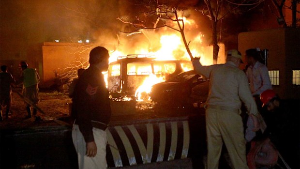A police officer and rescue workers arrive at the site of bomb blast in Quetta, Pakistan.