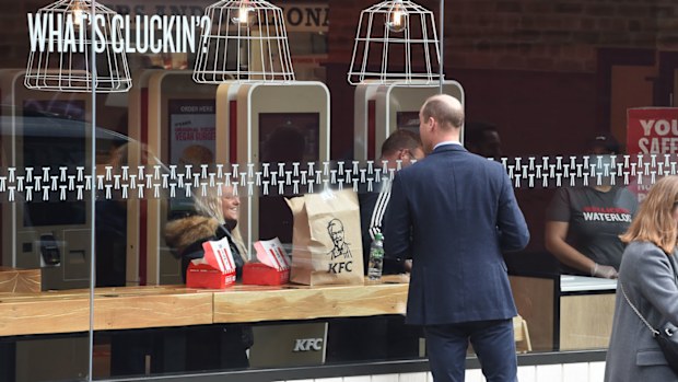 Prince William, Duke of Cambridge speaks to a member of the public through the window of a KFC restaurant before attending the launch of the Hold Still campaign at Waterloo Station on October 20, 2020 in London, England. 