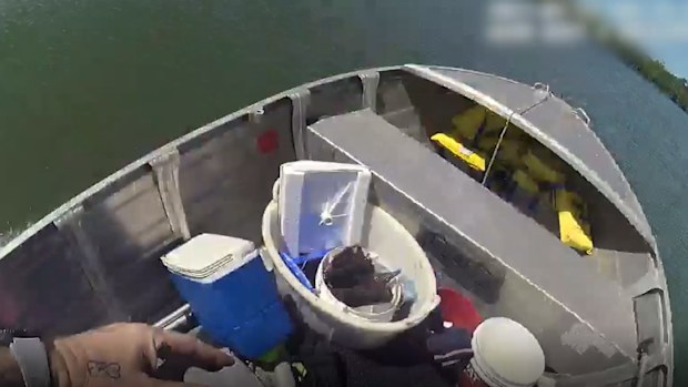 The police office jumps into the tinny, taking control of the runaway boat.