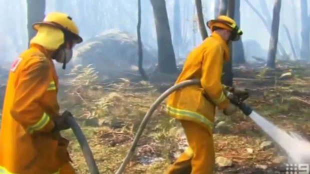 CFA members douse a fire.