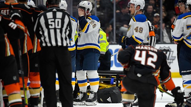 Players reacton the ice while Blues defenseman Jay Bouwmeester, who suffered a medical emergency, is worked on by medical personnel