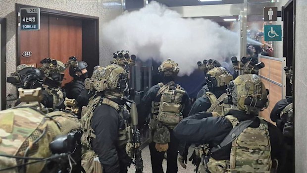 National Assembly employees spray a fire extinguisher towards soldiers in Seoul, South Korea.