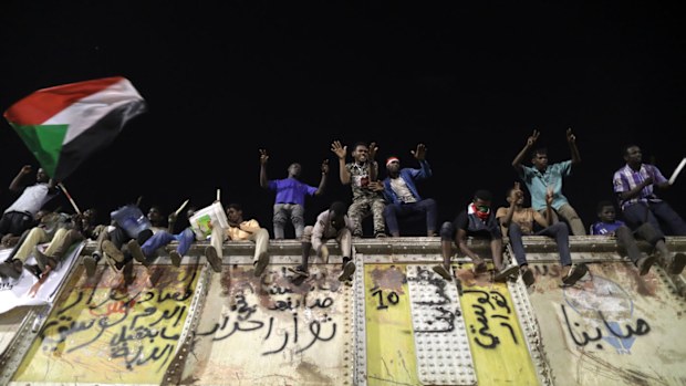 Sudanese protesters shout slogans from the top of a blocked rail road bridge at the site of a sit-in, near the Army headquarters, in Khartoum, Sudan.