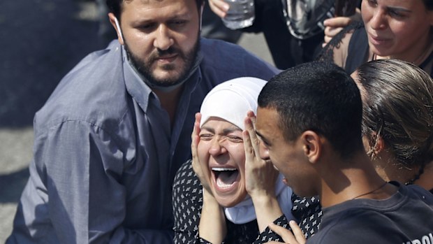 The wife of Rami Kaaki, one of ten firefighters who were killed during the last week's explosion that hit the seaport of Beirut, mourns during her husband's funeral at the firefighter headquarters, in Beirut, Lebanon, Tuesday, Aug. 11, 2020
