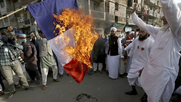 Supporters of religious group burn a representation of a French flag during a rally against French President Emmanuel Macron and republishing of caricatures of the Prophet Muhammad they deem blasphemous, in Karachi, Pakistan, Friday, Oct. 30, 2020