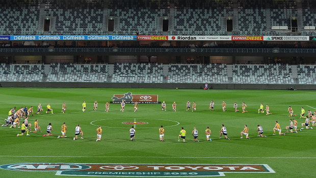 Players take take a knee in support of the Black Lives Matter movement before the round 2 AFL match