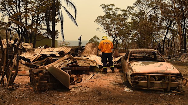 RFS Development Assessment & Planning Officer Adam Small inspects a burnt out home and out building near Balmoral during the Green Wattle Creek fire.