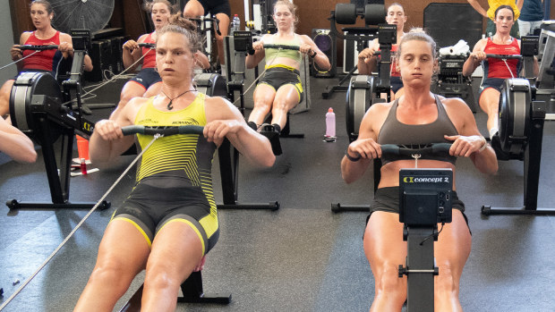 Rowena Meredith (left) and Georgie Rowe thrashing themselves on the ergs.