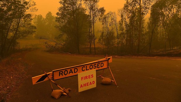 A road closure sign on the intersection of The River Road and the Kings Highway which are both closed due to the fire near Batemans Bay.