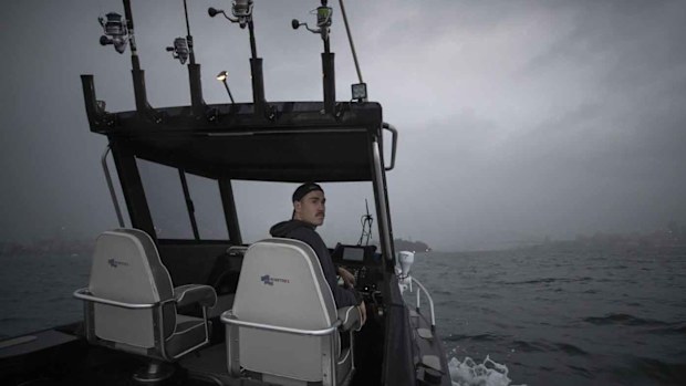 Greater Western Sydney Giants AFL player Jeremy Cameron drives his boat while out fishing on Sydney Harbour.