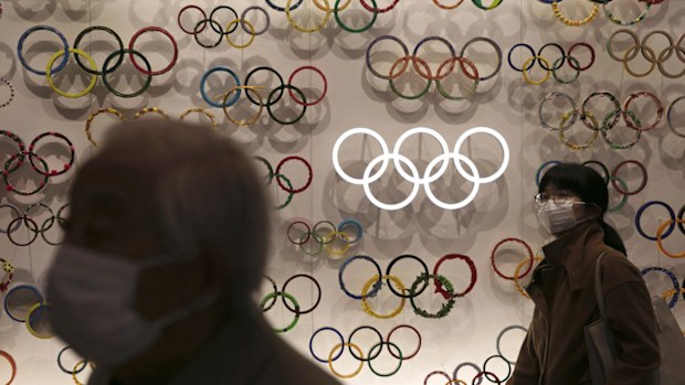 Two people wear masks as they visit the newly opened Japan Olympic Museum located near the New National Stadium, Sunday, Feb. 23, 2020, in Tokyo.