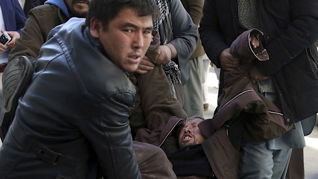 A man is carried into a hospital in tears after a suicide attack in Kabul, Afghanistan. (AAP)