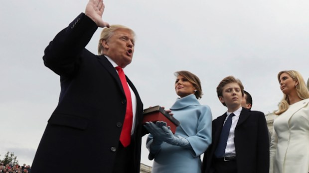 Donald Trump holds hand on bible during inauguration. 