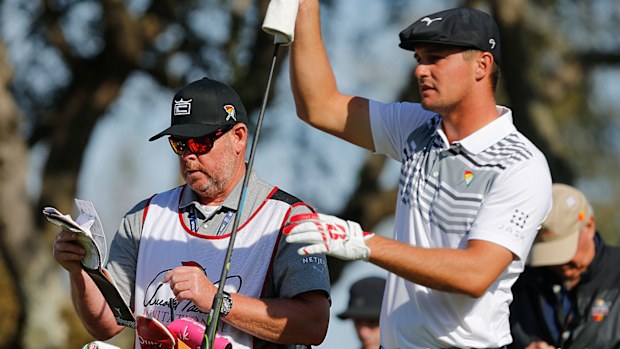 Bryson DeChambeau and his caddie Tim Tucker go over yardage