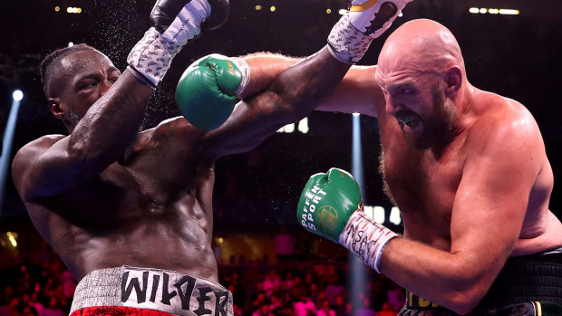 Tyson Fury (R) punches Deontay Wilder during their WBC Heavyweight Championship title fight 