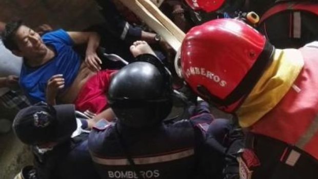 Manuel Vasquez is pulled from the building by rescuers.