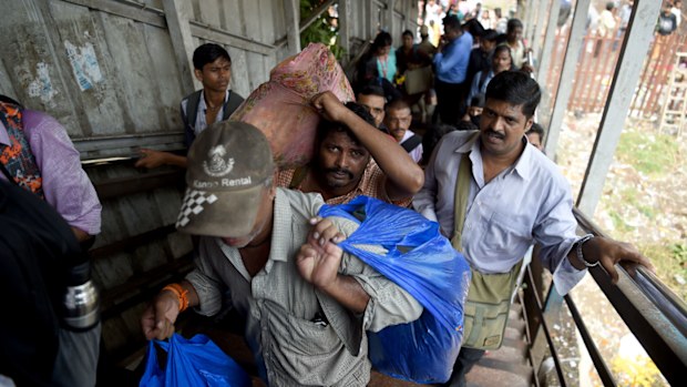 Indian pedestrians walk through the scene of a stampede on a railway bridge in Mumbai. (AFP)