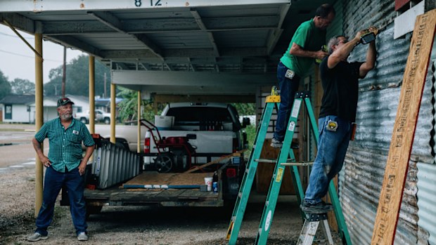 Workers board up a workshop ahead of Hurricane Delta in Abbeville, Louisiana, on October 8, 2020. 