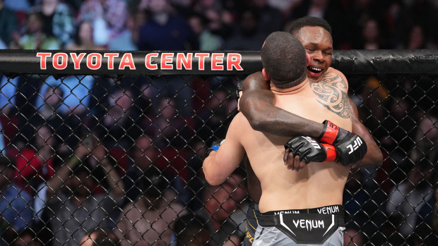 Robert Whittaker and Israel Adesanya embrace after finishing five rounds