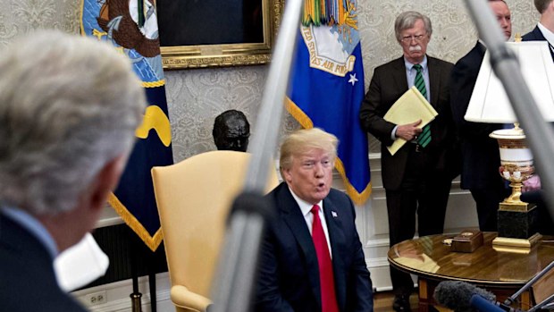 John Bolton listens to Donald Trump speaking in the Oval Office. (AAP)