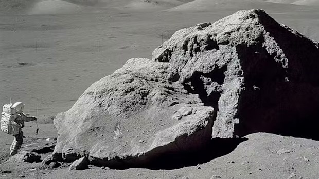 Apollo 17 astronaut Harrison H. Schmitt walks near a massive rock on the moon in 1972, in what was the final mission of NASA's Apollo program.