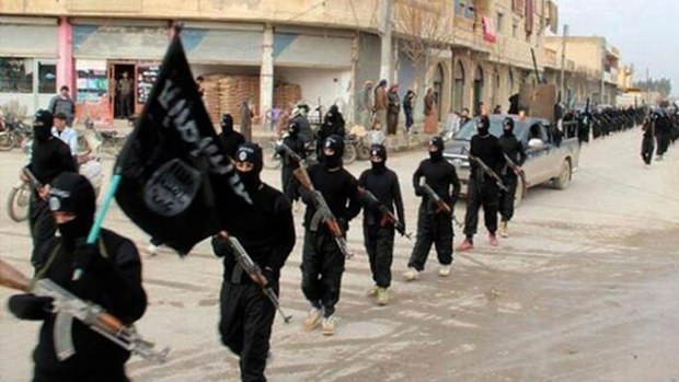 ISIL fighters parade down a street.