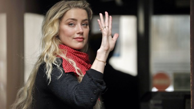 American actress Amber Heard smiles at the media as she arrives at the High Court in London, Thursday, July 23, 2020.