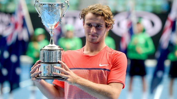 Queensland teen Oliver Anderson holds the winner's trophy after victory in the Junior Boys' Singles final against Jurabeck Karimov of Uzbekistan at the Australian Open in 2016. (AAP)