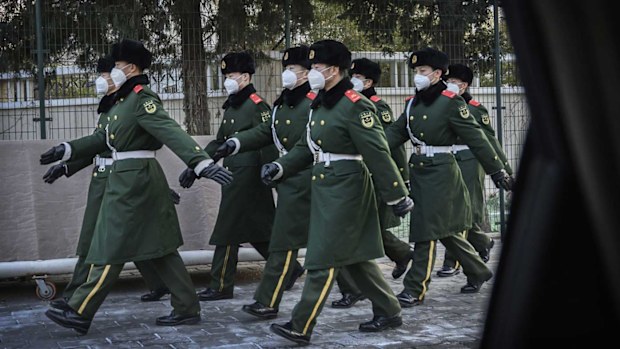 Police march wearing masks during a duty change on February 3, 2020 in Beijing, China.