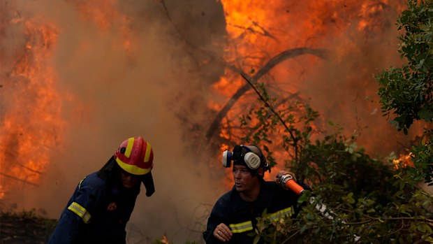 Firefighters battle a blaze in Ellinika village on Evia in Greece.