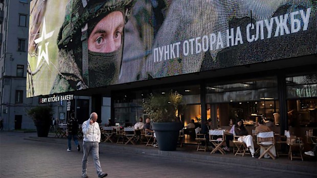 A Russian military recruitment sign above a Moscow cafe.
