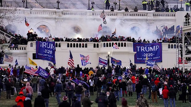 Protesters and rioters surrounding the US Capitol building.