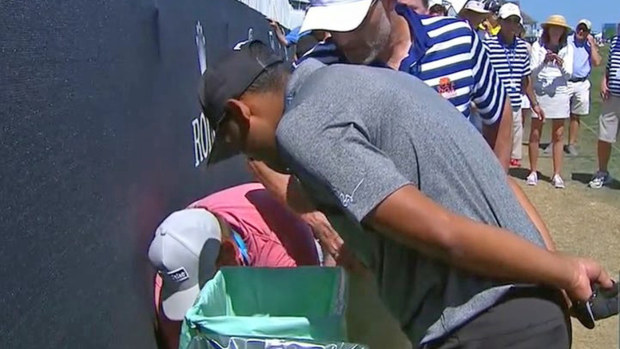Sebastian Munoz looks for his ball in the trash